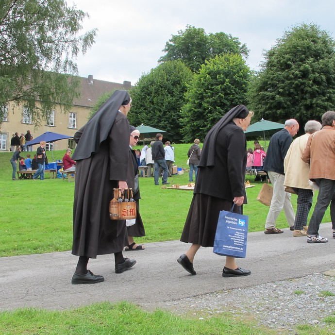 Auf dem Foto sieht man zwei Schwestern und Besucher mit ihren Einkäufen über den Markt schlendern.

Foto: LWL (öffnet vergrößerte Bildansicht)