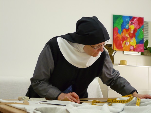 Das Bild zeigt eine Nonne an einem Stiff im Porzess des Nähens.

Foto: Abtei Varensell