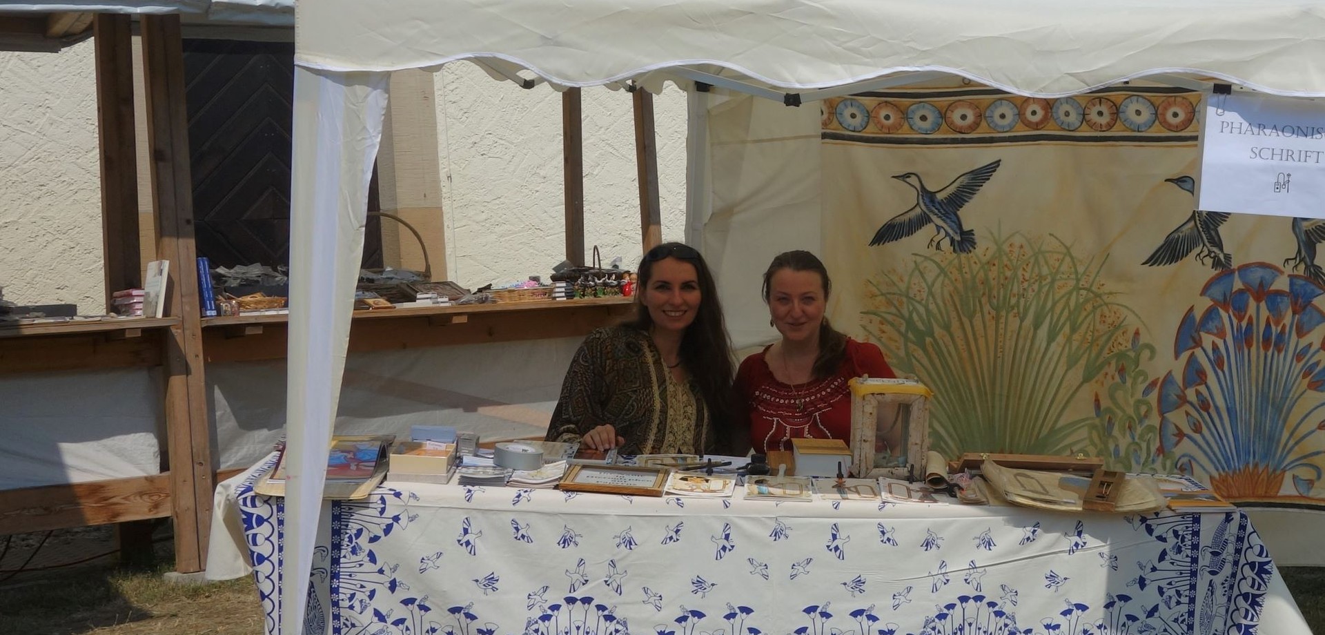 Auf dem Foto sieht man zwei Damen, die auf dem Klostermarkt die Namen in Hieroglyphen schreiben.

Foto: Koptisches Kloster Brenkhausen, D. Rustica