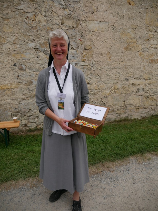 Auf dem Foto sieht man eine Ordensschwester mit einer Kiste voll Lose, auf denen Zitate der Ordensgründerin geschrieben stehen.

Foto: LWL