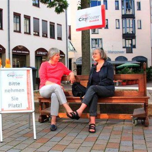 Auf dem Foto sieht man zwei Damen, die sich auf der Kirchenbank vom CityKloster unterhalten.

Foto: CityKloster Bielefeld